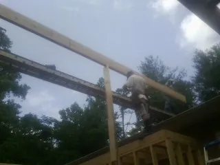 Carpenter setting a ridge beam over a new addition frame — Ice Dam Removal by Roofing Brothers in La Verne