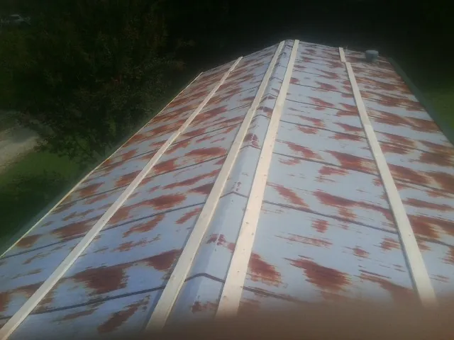 Rusted metal roof panels with new wood purlins before replacement — Storm Damage Roof Repair in La Verne by Roofing Brothers
