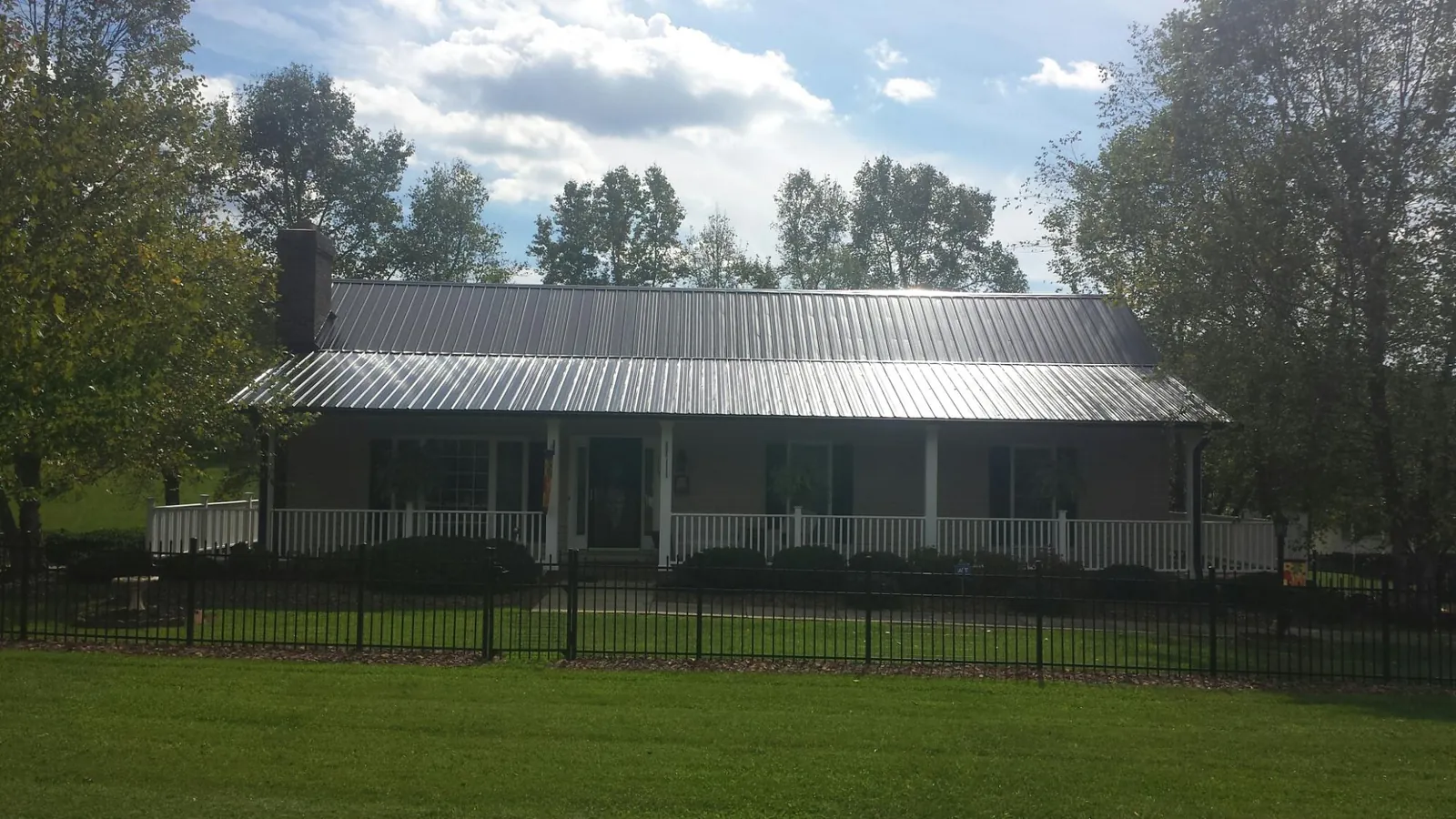 Gray metal roof on a brick ranch with a full width front porch — Gutter Guard Installation work by our crew in La Verne
